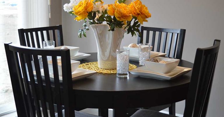 Dining room table with flowers in vase sitting on top