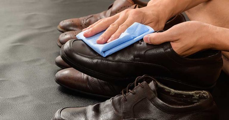 Someone cleaning a pair of leather shoes