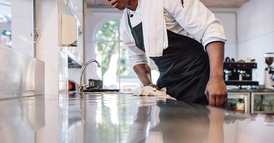 A staff member cleaning counters in a restaurant