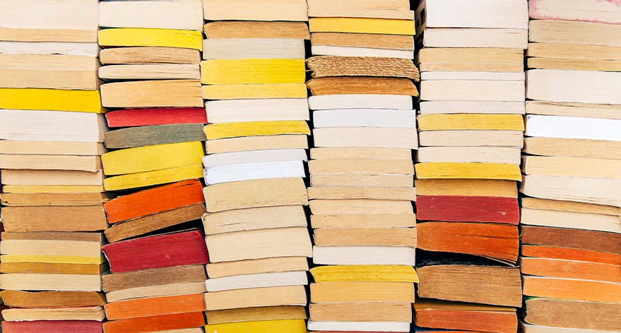 Stacks of yellow, red and brown books.