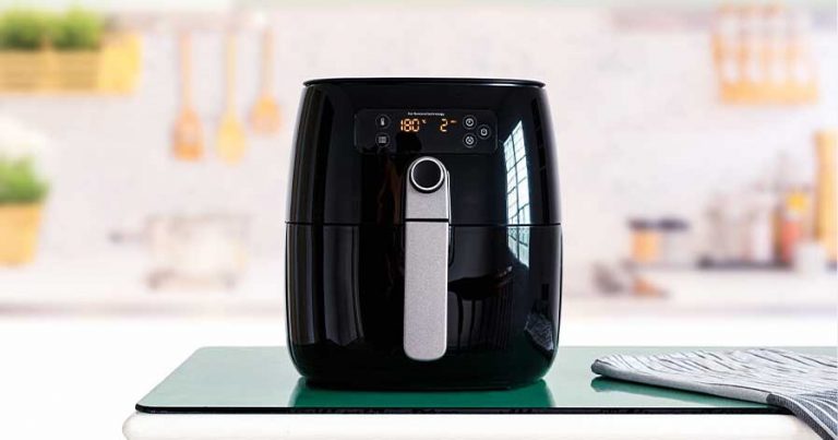 A picture of a black air fryer sitting on a countertop.