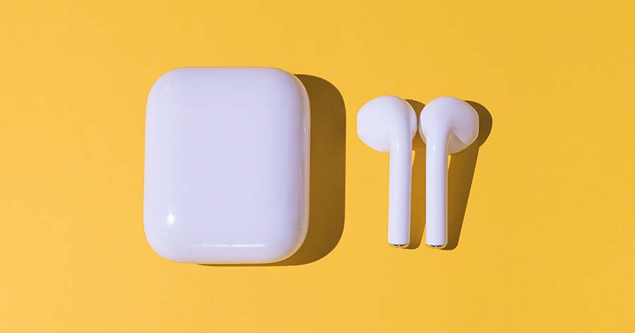 An AirPods case and a pair of AirPods against a yellow background.